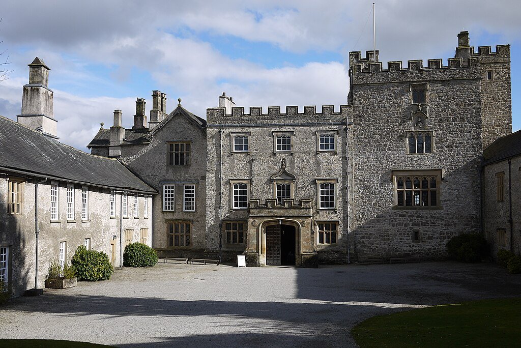 Exterior view of Sizergh Castle featuring stone walls and a central entrance. Exterior view of Sizergh Castle featuring stone walls and a central entrance.