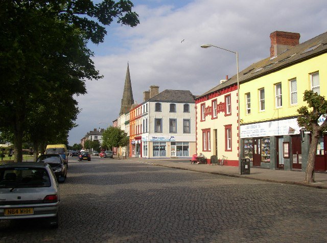 View of a cobbled street in Silloth featuring buildings and trees along the roadside. View of a cobbled street in Silloth featuring buildings and trees along the roadside.