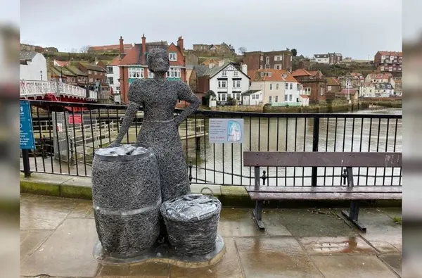 a statue of a woman and a barrel